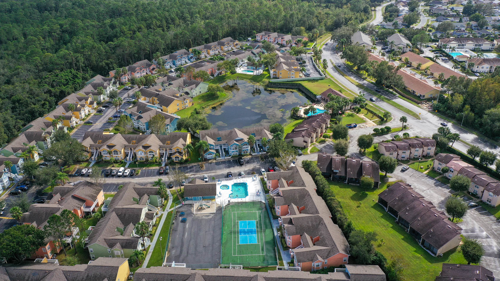 drone shot of condo community with pool and tennis courts